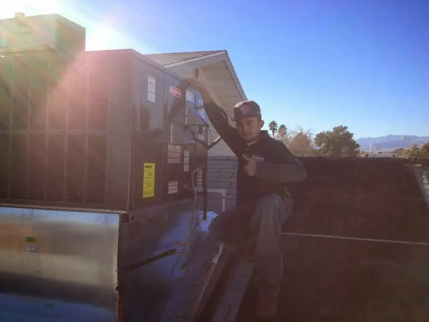 HVAC technician performing AC Tune-Up on a rooftop unit in Etowah